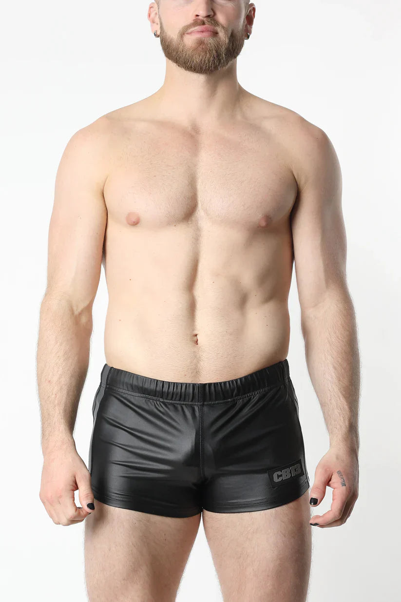 Black shiny faux leather anti-chrome gear short with subtle logo on the lower right leg front view
