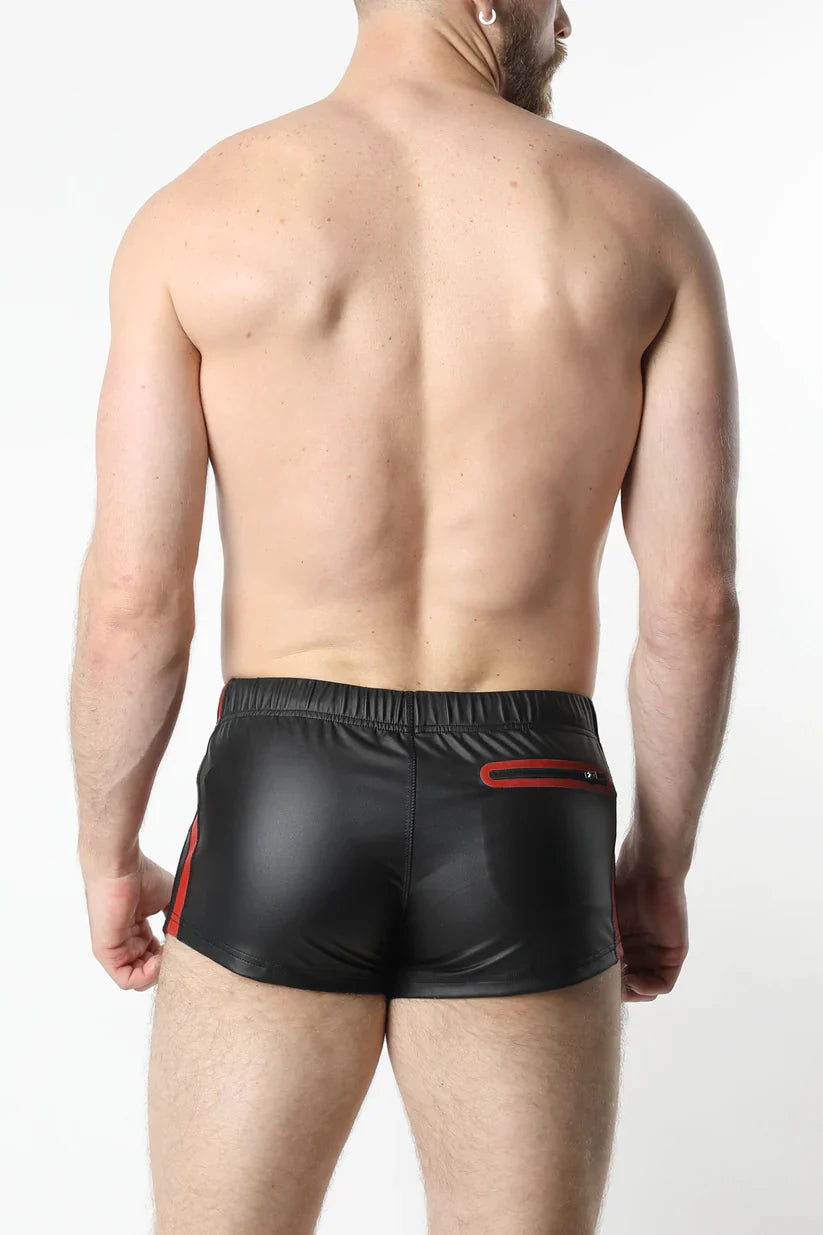 Black shiny faux leather anti-chrome gear shorts with red side stripes and back zipper pocket shown from the back