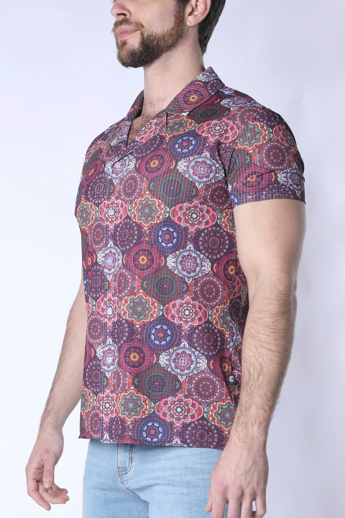 A man wearing a balboa button down shirt with a short-sleeved multicolored mandala pattern in purple pink and green