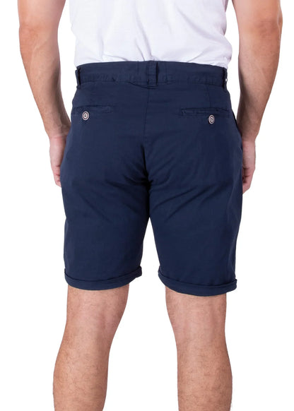 Rear view of a person wearing navy blue cotton shorts with rolled cuffs and buttoned back pockets.