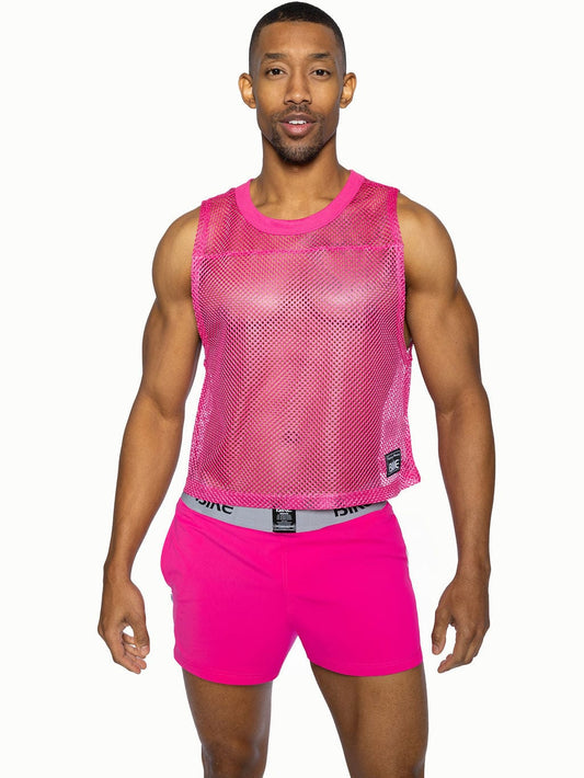 Bright pink mesh sleeveless practice jersey with rounded neckline and small black bike brand tag on lower right side