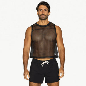 A person wears a black sleeveless mesh practice jersey with black shorts on a white background.