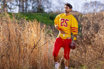 Yellow football jersey with red number 25 and stripes worn over red pants in bike athletic bas306 original jockstrap color yellow