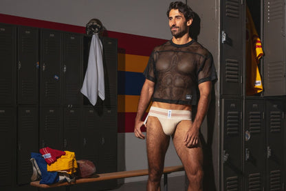 A man wearing a black mesh short-sleeved top and beige BIKE Athletic BAS333 classic retro 1980s jockstrap in vintage cream