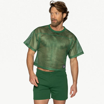 A person wears a forest green mesh practice jersey with short sleeves and matching green shorts.