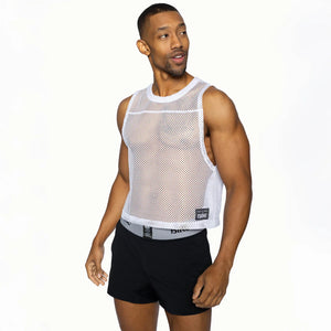 A person wearing a white mesh athletic sleeveless practice jersey and black shorts.
