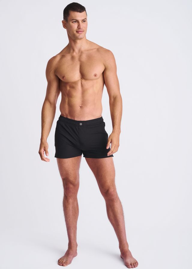 Black seersucker swim shorts with mesh lining featuring a simple sleek design and small button at the waistband