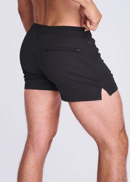 Back view of black seersucker swim shorts with mesh lining featuring a zippered back pocket and side slit