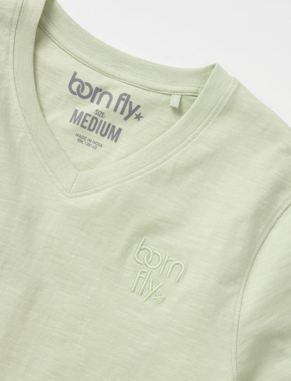A light green cotton born fly v-neck tee with subtle embroidered logo on the chest and matching inside collar tag