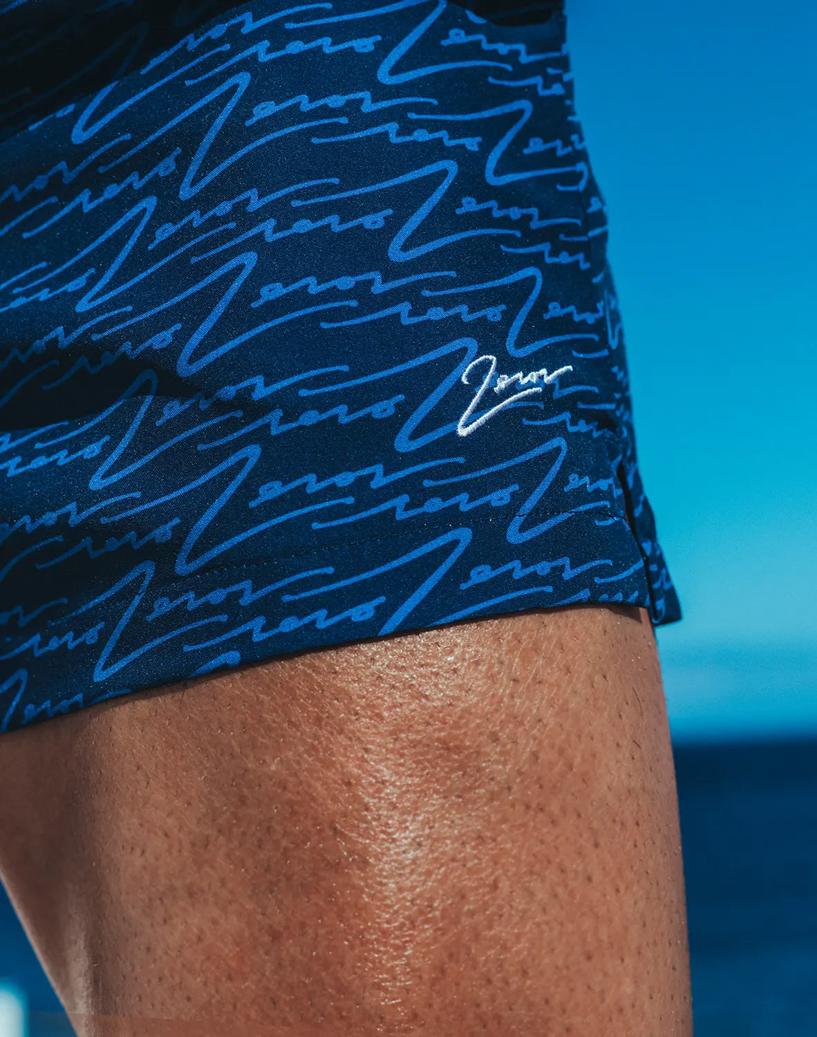 Dark blue byron swim short with light blue wave pattern and small white signature logo on the side
