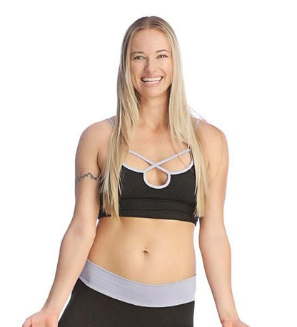 Black sports bra top with white crisscross straps and matching light gray waistband for active wear