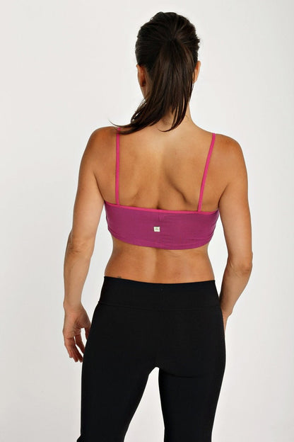 A vibrant magenta bra top plum with thin matching straps and a sleek form fitting sports design