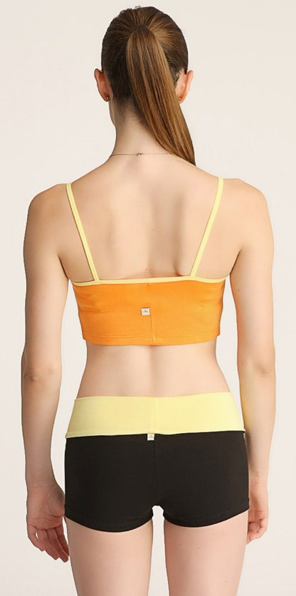 Orange and yellow strap sports bra paired with black bumble short shorts for activewear use
