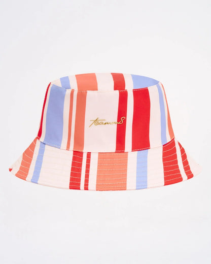 Cabana bucket hat with vibrant red blue and cream vertical stripes and subtle gold embroidered logo on front