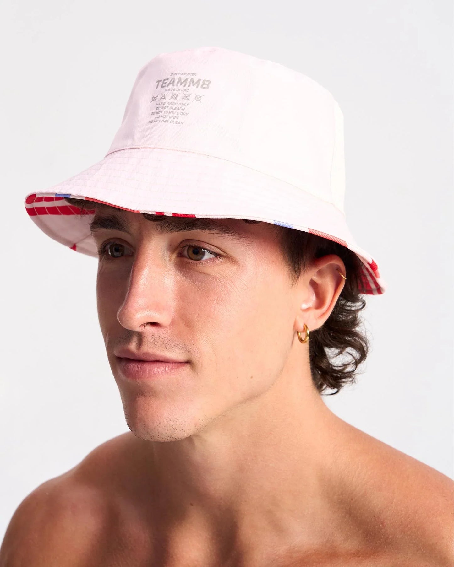White cabana bucket hat with red and blue striped brim and teammb branding in a casual summer design