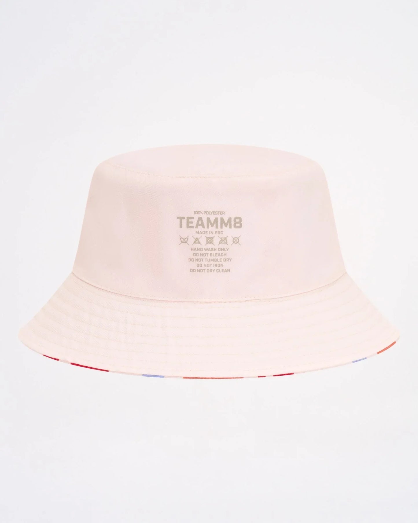 A soft blush pink cabana bucket hat featuring a subtle striped trim along the brim