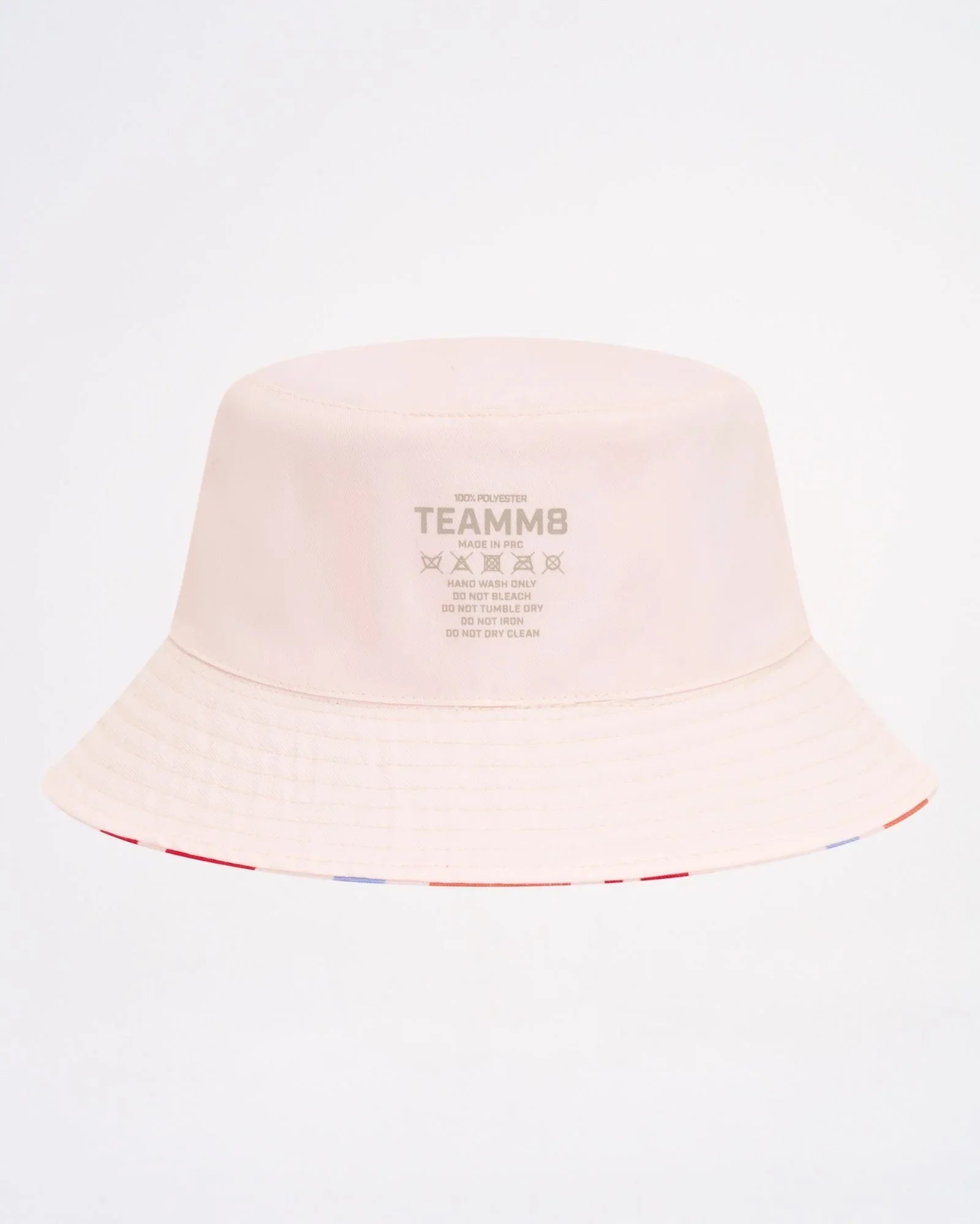 A soft blush pink cabana bucket hat featuring a subtle striped trim along the brim