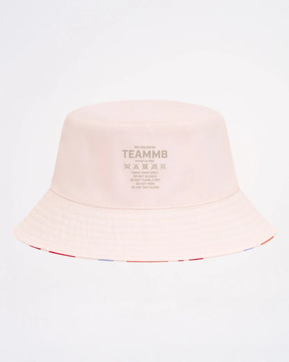 A soft blush pink cabana bucket hat featuring a subtle striped trim along the brim