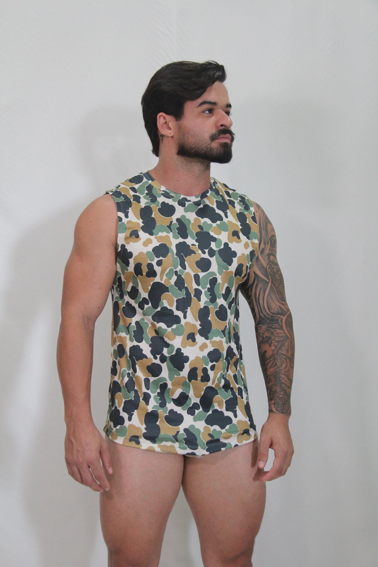 A men’s sleeveless camouflage open arm tank top with green brown and black pattern on white base