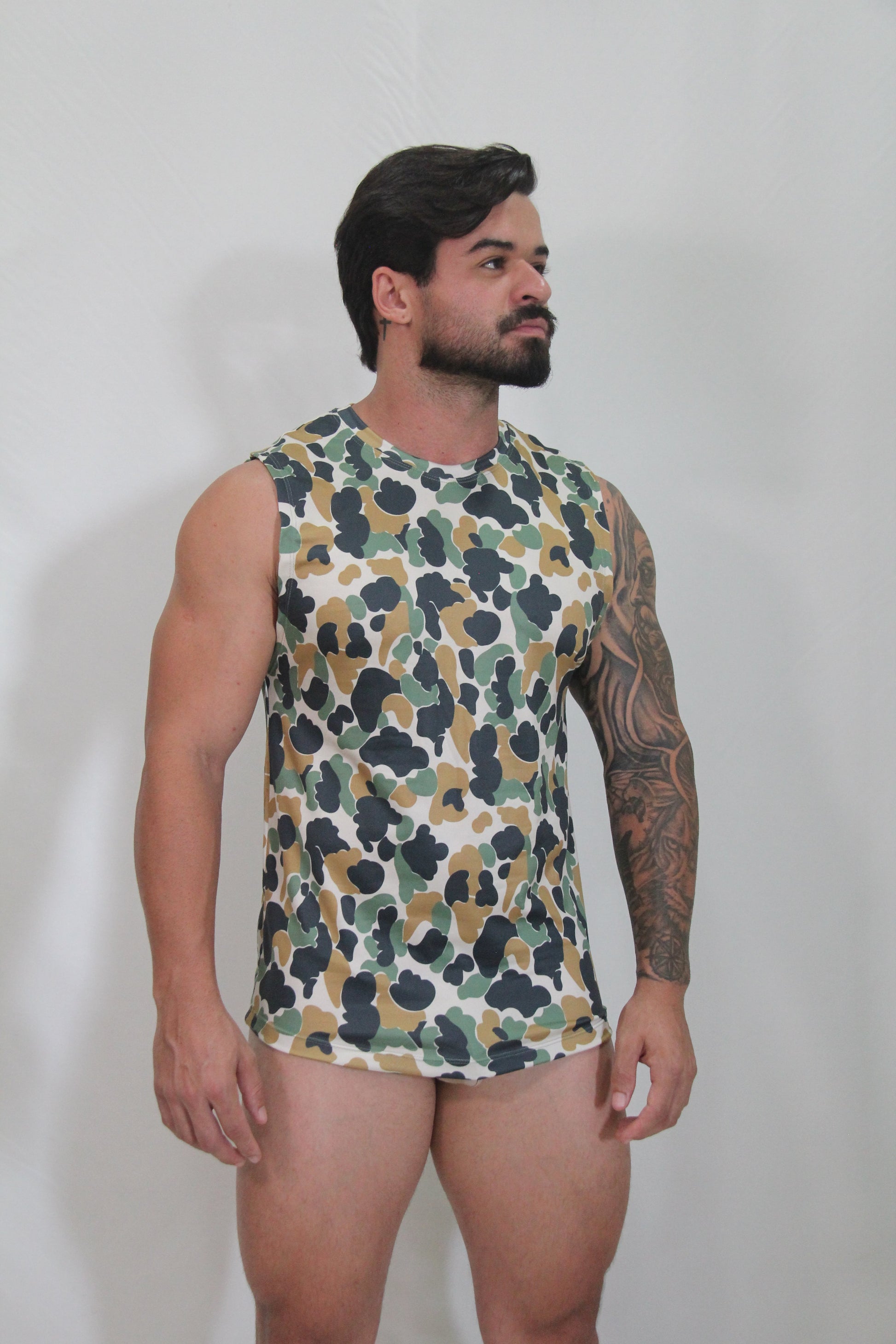 A men’s sleeveless camouflage open arm tank top with green brown and black pattern on white base