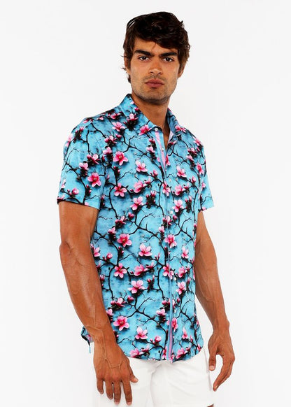 A vibrant turquoise 3D print stretch knit shirt with bold pink cherry blossoms on dark branches, short-sleeved button-up design