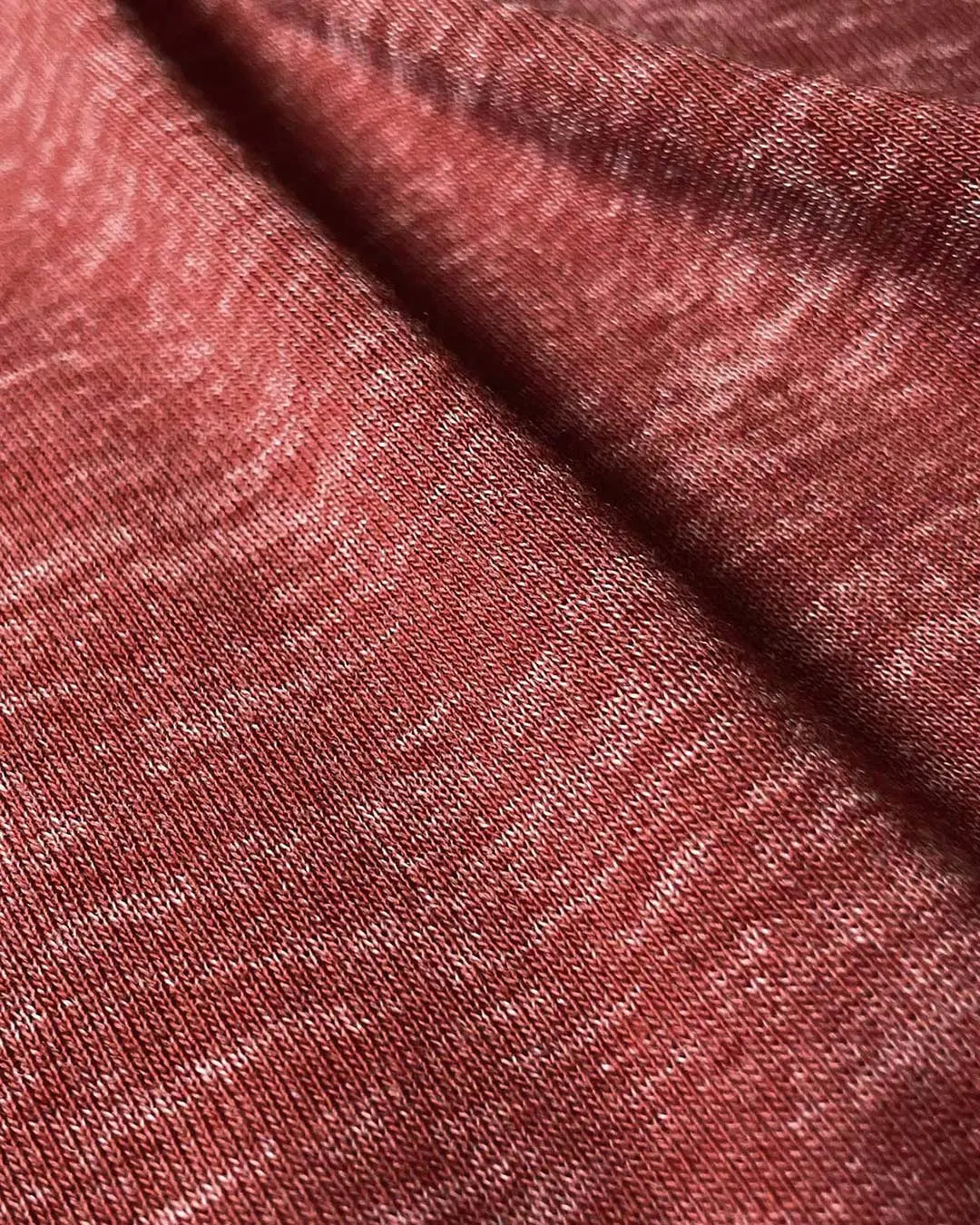 Close-up of textured red fabric with a subtle heather pattern made by C-IN2
