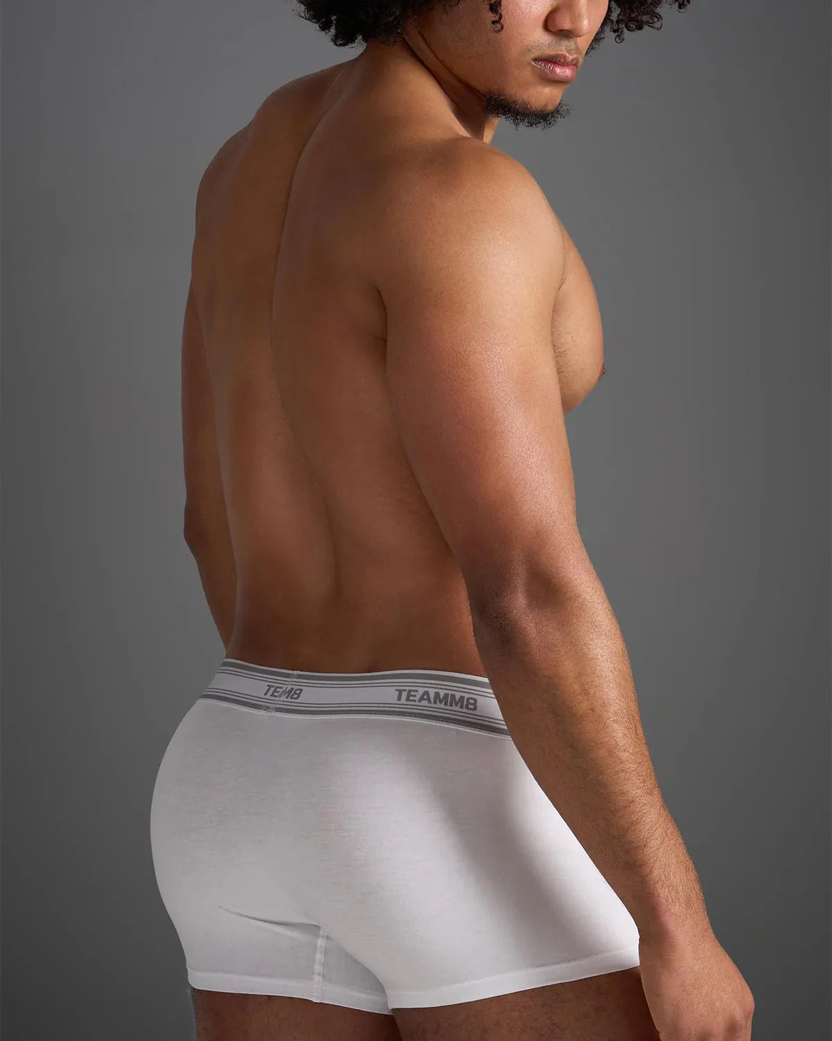 White classic cotton trunk boxer briefs with a gray elastic waistband featuring black brand name lettering