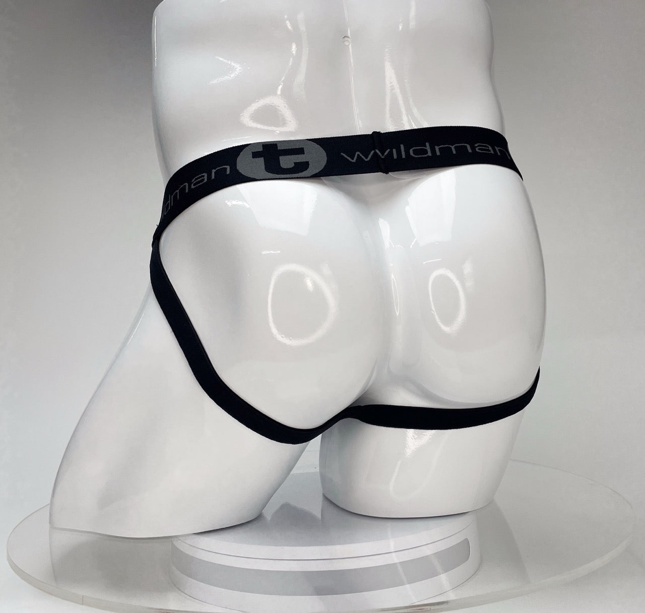 White WildmanT Big Boy jockstrap on a mannequin, featuring a black waistband with the brand name and logo.