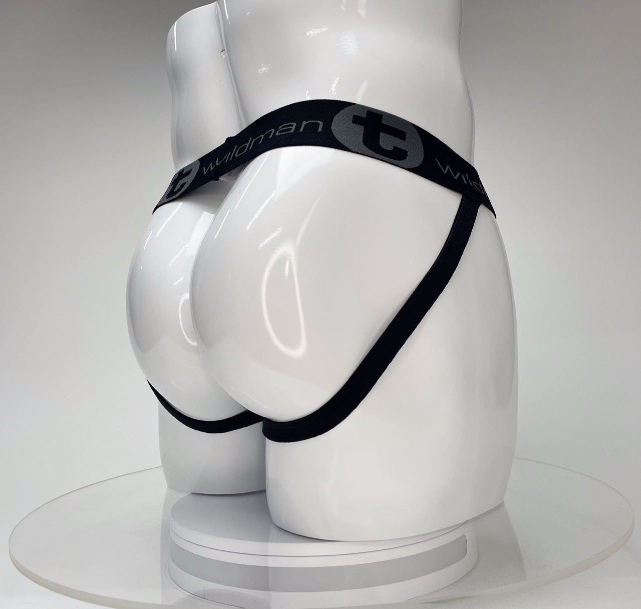White jockstrap on a mannequin, featuring a black branded waistband with "Wildman" and "T" logo.
