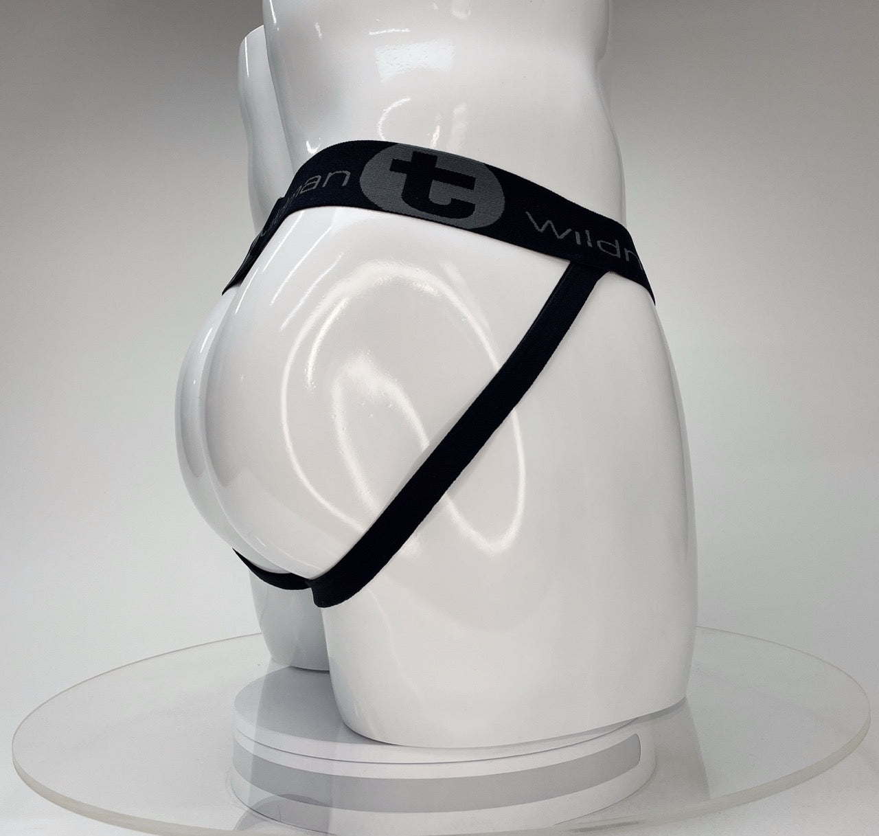 White mannequin wearing a black WildmanT jockstrap with a branded elastic waistband and side straps.