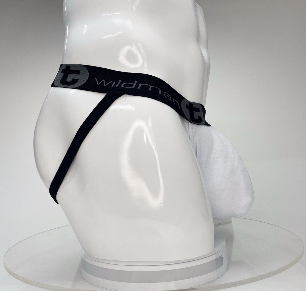 White WildmanT jockstrap with a large front pouch and a black branded waistband on a white mannequin.