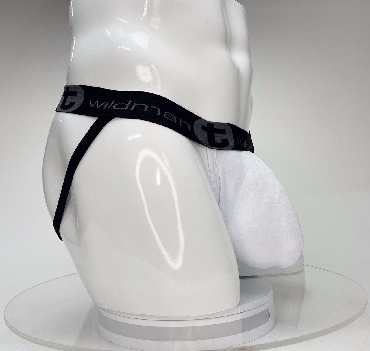 White WildmanT Big Boy pouch jockstrap on a mannequin, featuring a black branded elastic waistband.