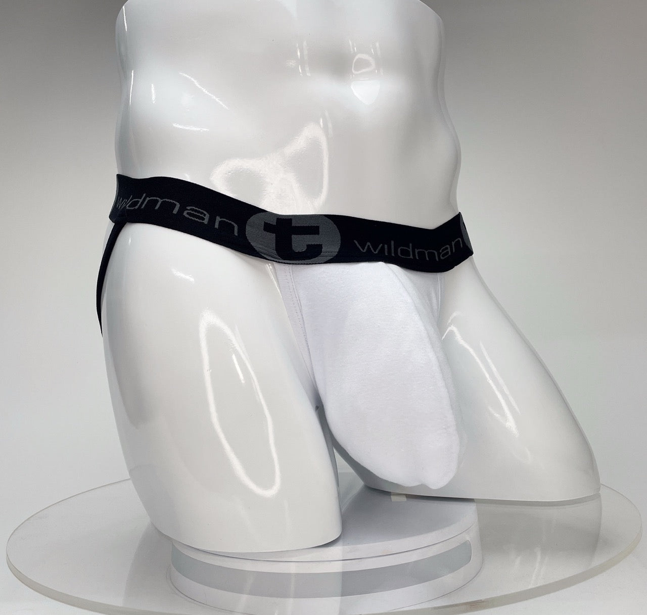 White jockstrap with a large front pouch and a black branded elastic waistband on a white mannequin torso.