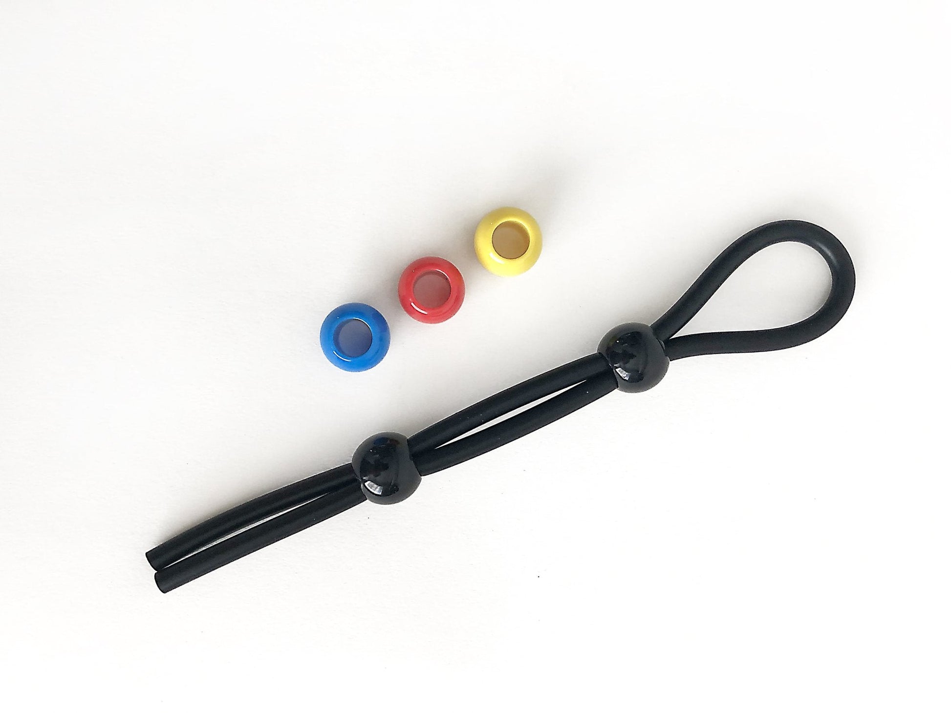 Black elastic cock leash double with glossy black beads and three colorful plastic rings in blue red and yellow
