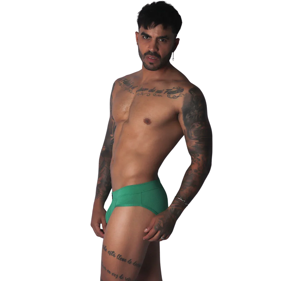 Green ribbed fabric brief with a solid waistband and a form-fitting cut worn by a tattooed man.