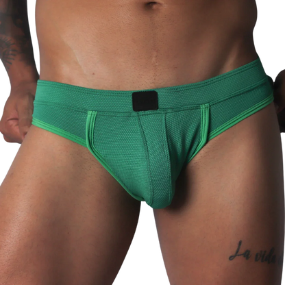 Green jockstrap featuring a textured honeycomb fabric, wide waistband, and a solid black central logo patch.