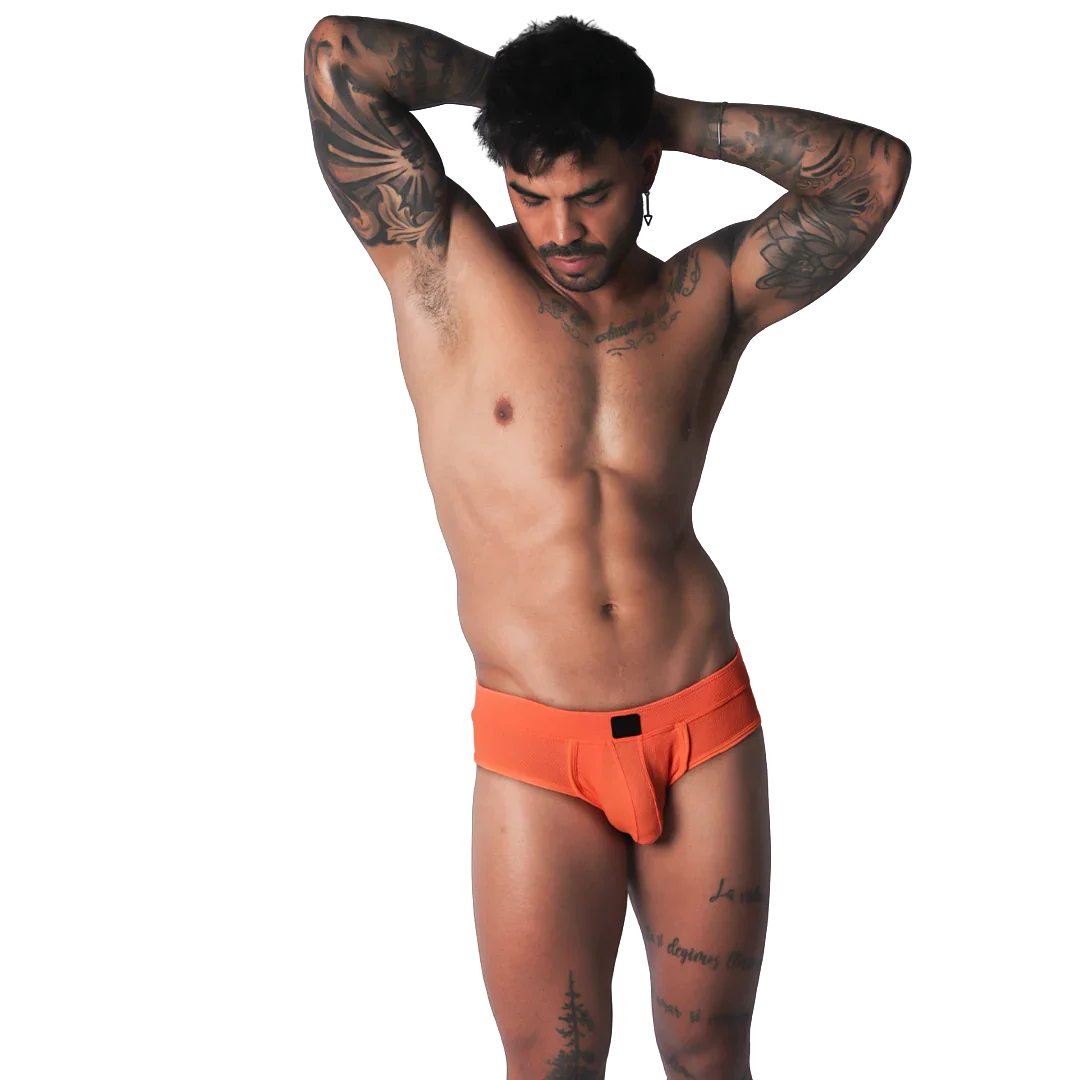 Bright orange low-rise brief in a textured, breathable fabric with a small black center-front logo patch.