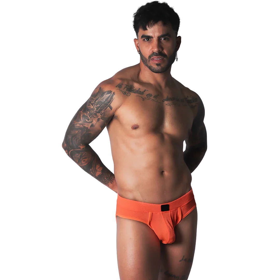 Bright orange athletic mesh jockstrap with a black logo patch on the center waistband, worn by a muscular man.