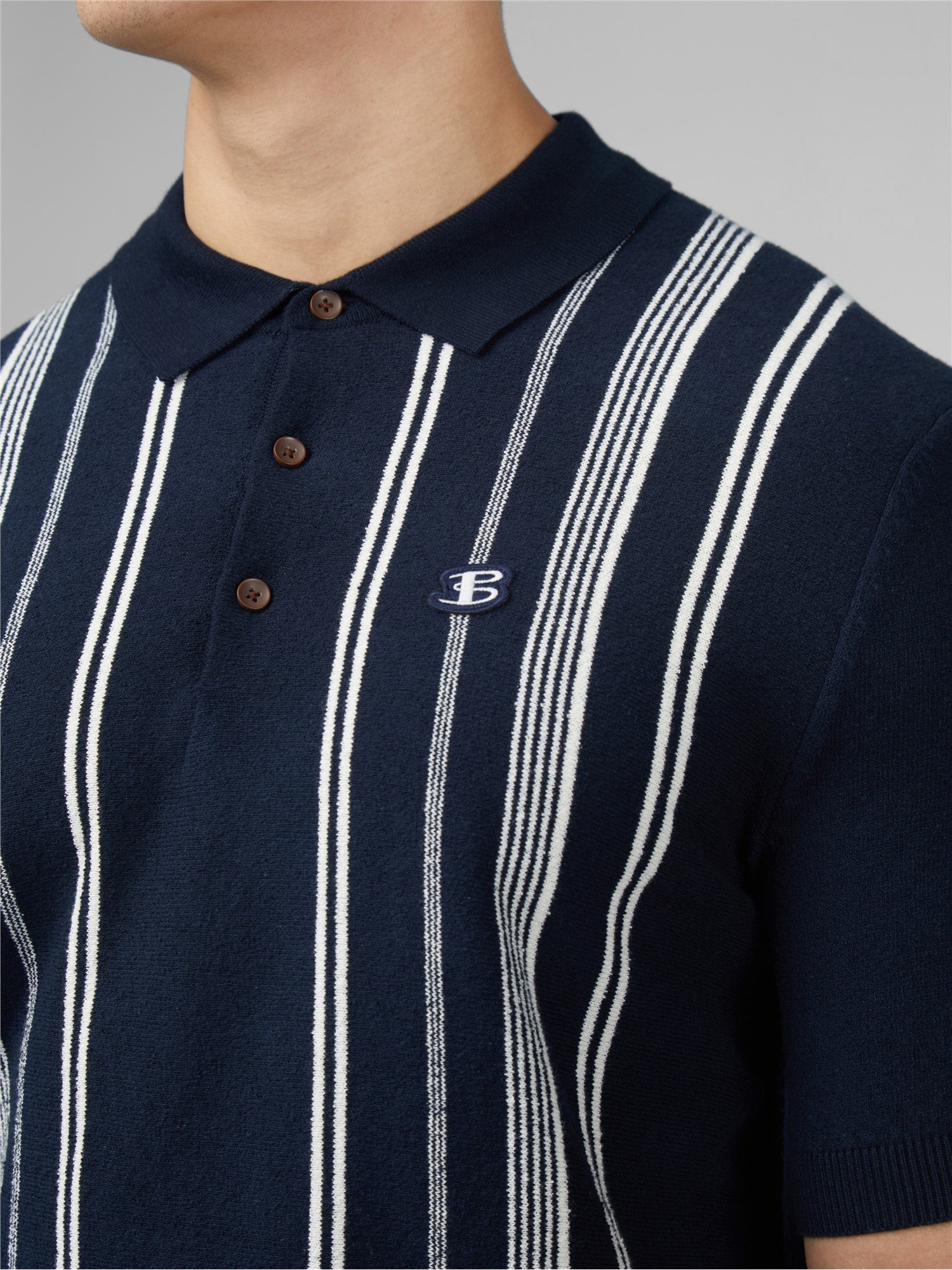 Navy blue and white vertically striped crinkle cotton polo shirt with a small embroidered logo on the left chest