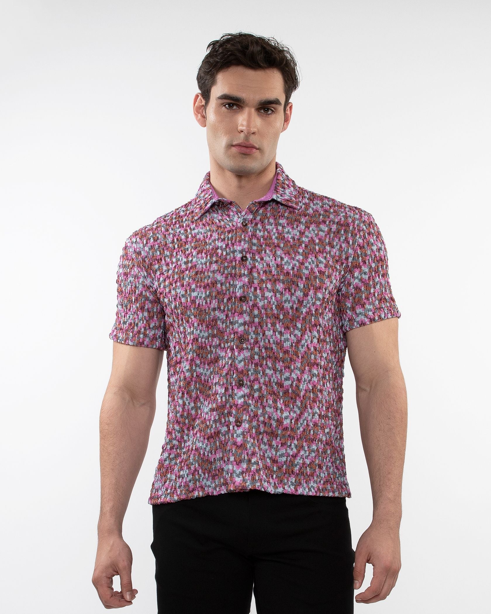 A man wearing a vibrant pink and white crinkle knit short sleeve shirt with a floral pattern