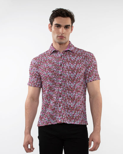 A man wearing a vibrant pink and white crinkle knit short sleeve shirt with a floral pattern
