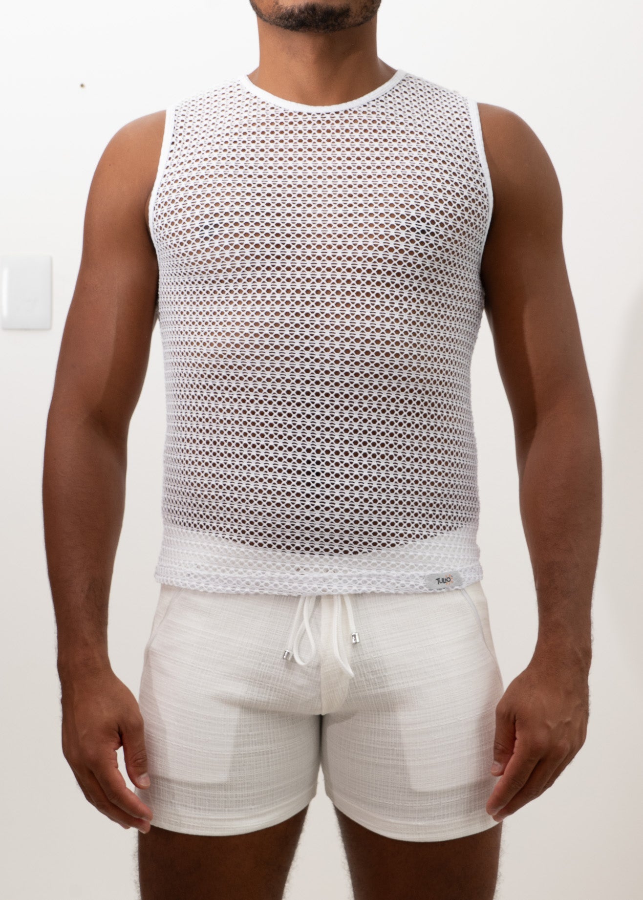 White crochet muscle tank top with mesh fabric round neckline and elasticated waistband front view