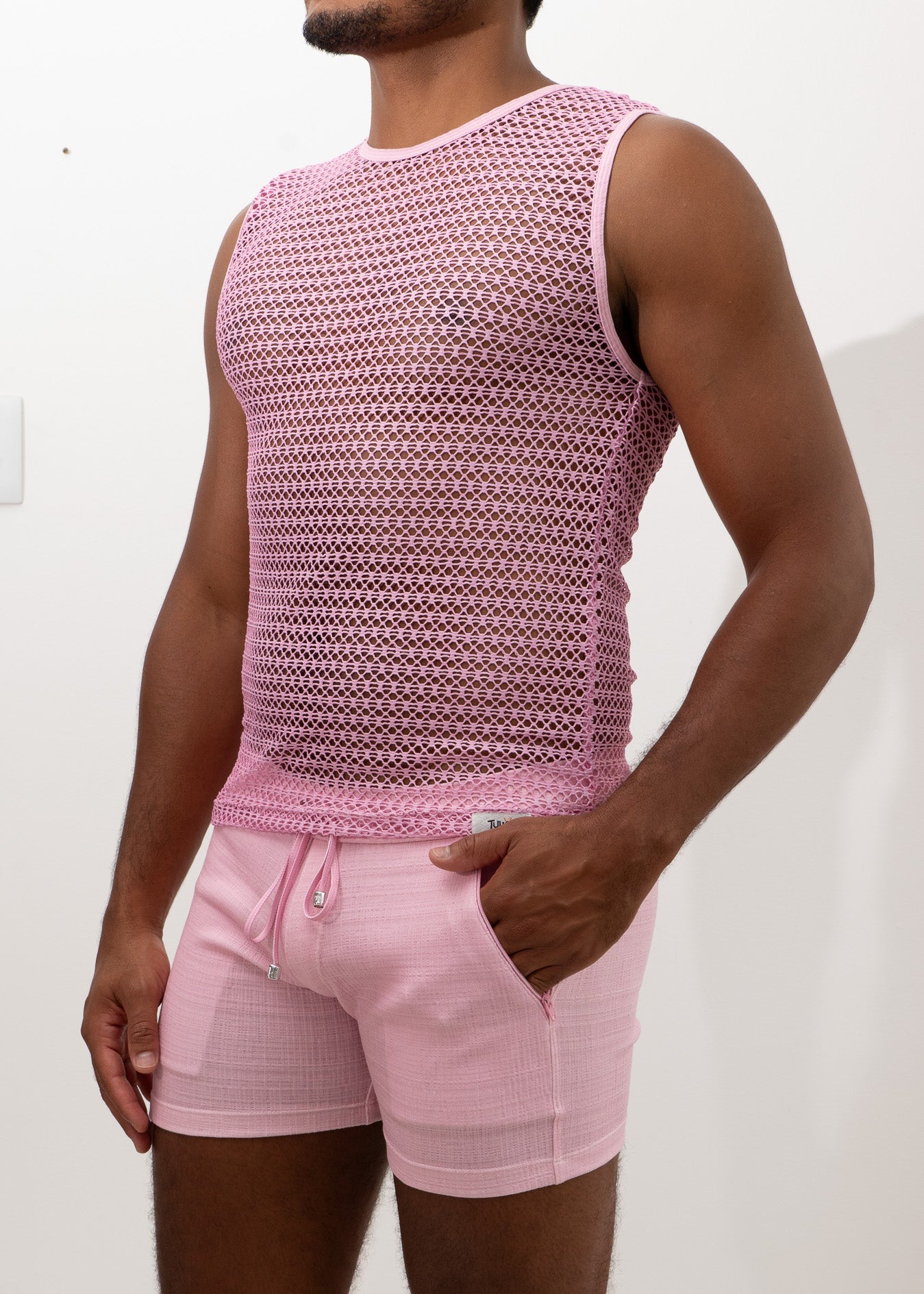 Crochet muscle tank top in pink mesh with subtle geometric pattern paired with matching pink drawstring shorts