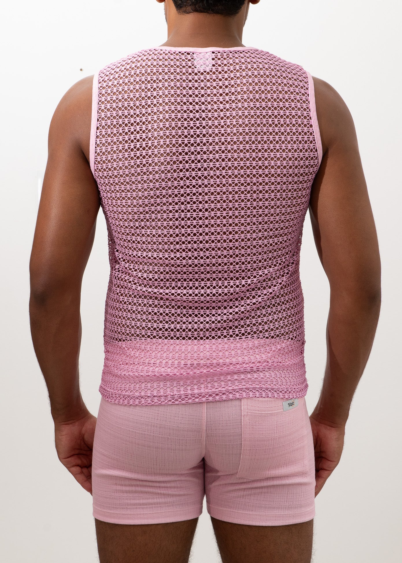 Pink crochet muscle tank top with mesh fabric subtle geometric pattern and ribbed hem for casual wear