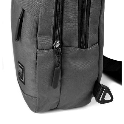 Dark gray canvas crossbody sling bag with black zippers and small square logo patch for everyday use