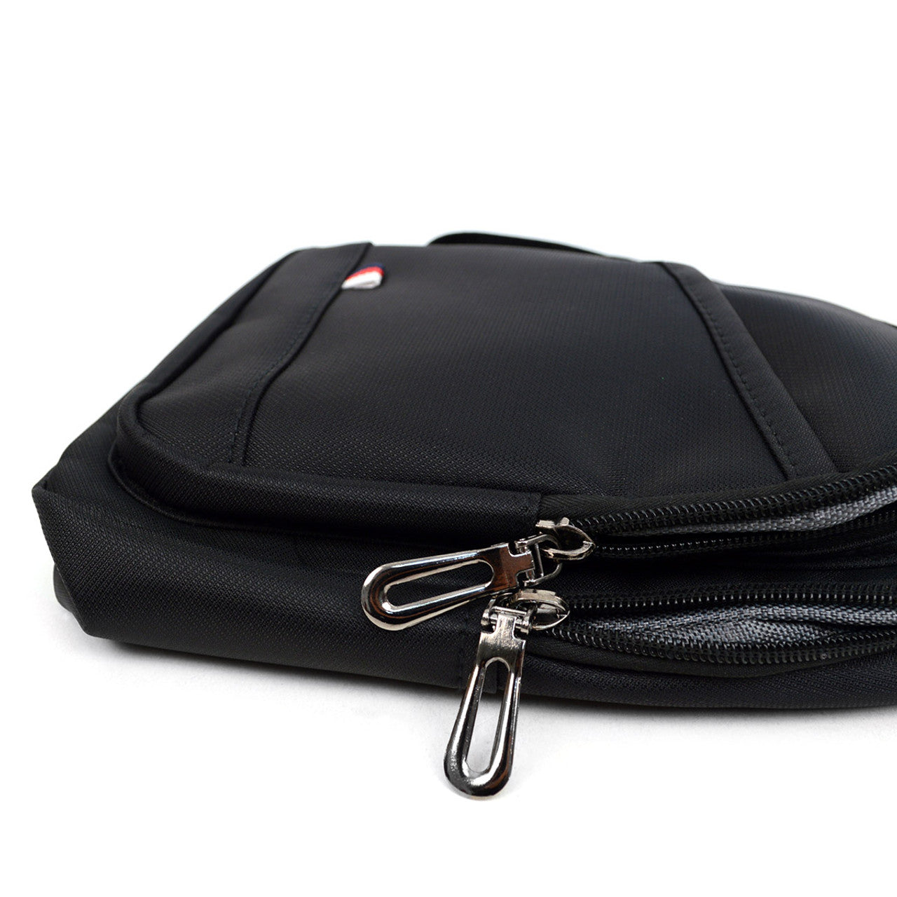 Black nylon crossbody sling bag with silver zipper pulls and small red white and blue logo on the front