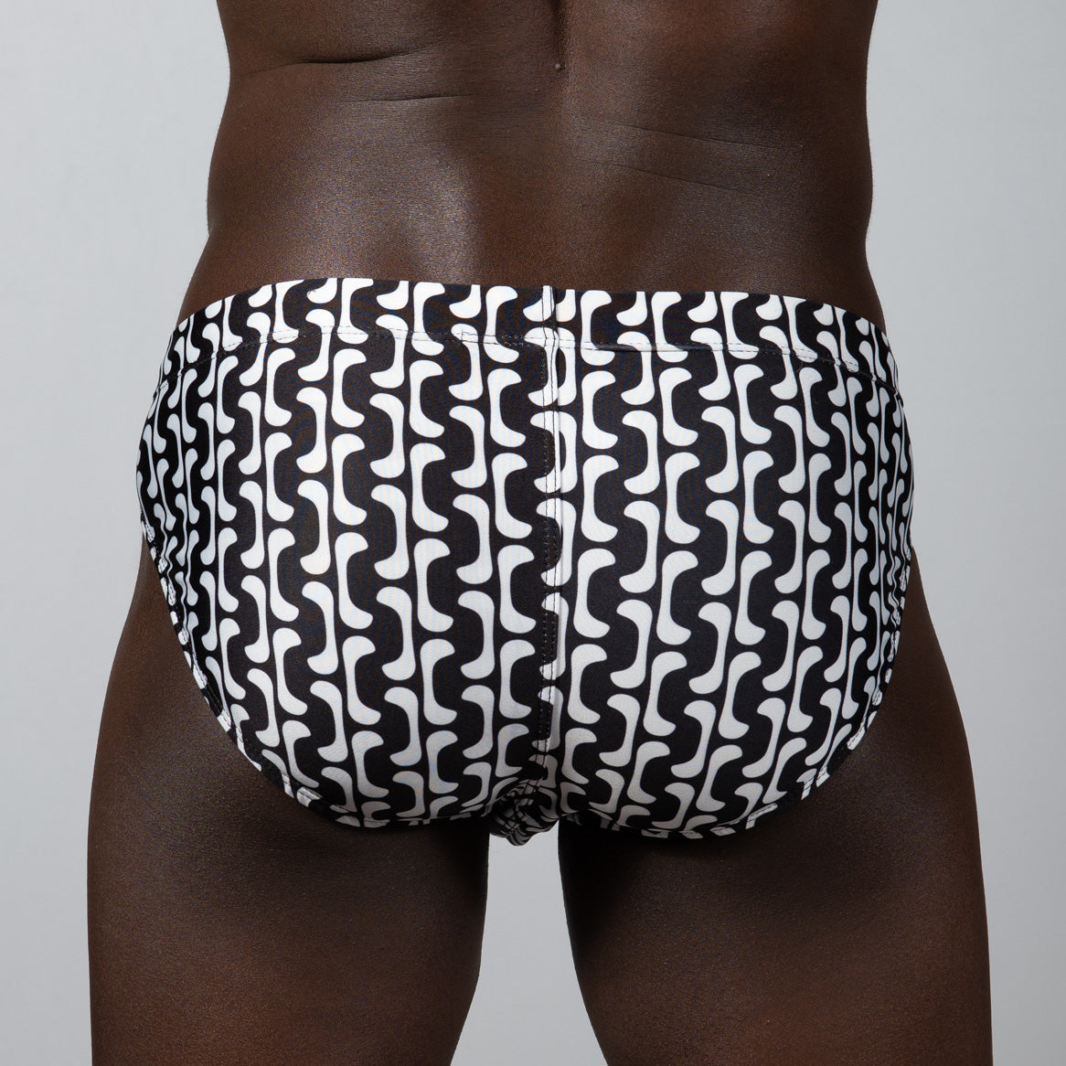 Black and white patterned swim trunks with a bold wavy geometric design in curves print brief style