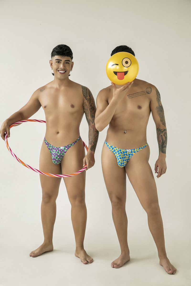 The man wears CandyMan 99924 thongs with a colorful purple and green floral pattern in turquoise fabric