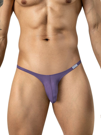 A muscular male model wears lilac low-rise briefs featuring thin side straps and a small logo tag.