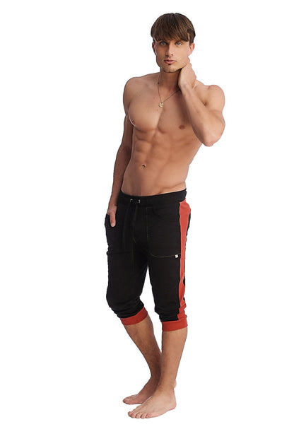 Black cuffed yoga pants featuring bold cinnabar red side stripes and matching red cuffs for active wear
